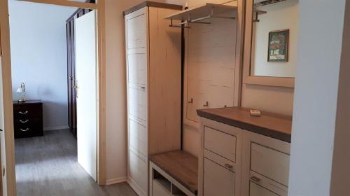 a bathroom with a closet with wooden cabinets and a sink at Apartma Lilu in Koper