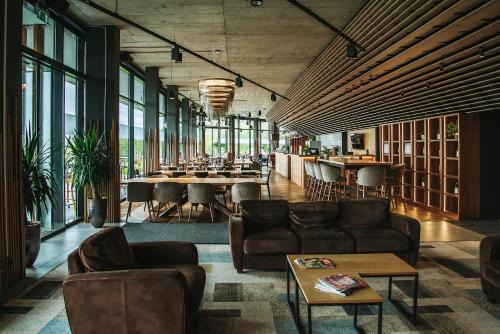 a lobby with couches and tables in a restaurant at Lajvér Borbirtok in Szálka