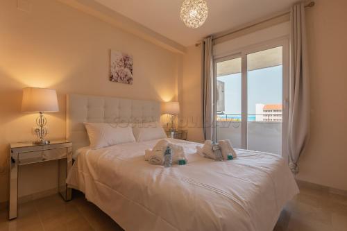 1 dormitorio con 1 cama con 2 toallas en Manilva Playa en Manilva
