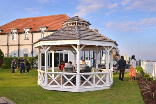a gazebo with people sitting in it in a yard at Kingscliff, BW Signature Collection in Clacton-on-Sea