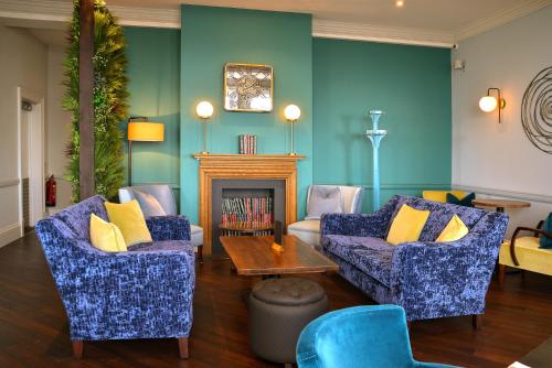 a living room with two couches and a fireplace at Kingscliff Hotel in Clacton-on-Sea