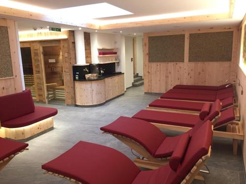 a row of red chairs in a waiting room at Berghotel Alpenklang in Grossarl
