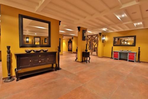 a large room with yellow walls and a large mirror at Sayaji Rajkot in Rajkot