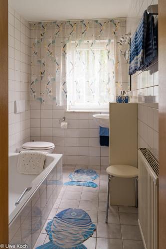 a bathroom with a tub and a toilet and a sink at Ferienwohnung Seeberger in Friedrichshafen