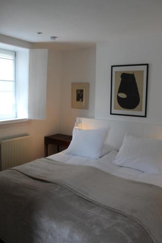 een bed met witte lakens en kussens in een slaapkamer bij Holiday Home Huis Dujardin 1 in Antwerpen