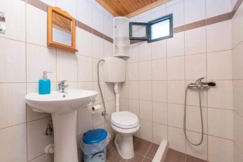 a bathroom with a toilet and a sink and a shower at Julie's Hermes house in Skala Kallirachis