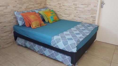 a bed with colorful pillows on top of it at Loft Aconchegante em Petrópolis in Petrópolis