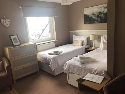 a bedroom with two beds and a window at The Shepherd's Rest in Alnwick