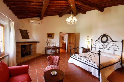 1 dormitorio con 1 cama y chimenea en Tenuta La Santissima, en San Rocco a Pilli