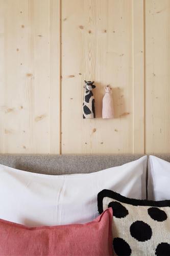 a bedroom with a wooden wall with two stuffed animals at Pension Alpenfluh in Lech am Arlberg