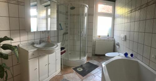 uma casa de banho com uma banheira, um lavatório e um WC. em Zimmervermietung Barth em Bernburg
