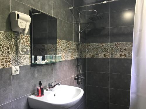 a bathroom with a sink and a shower at Guest House Maradona in Sighnaghi