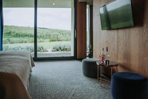 a hotel room with a bed and a flat screen tv at Lajvér Borbirtok in Szálka