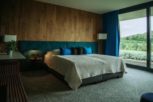 a bedroom with a large bed and a large window at Lajvér Borbirtok in Szálka