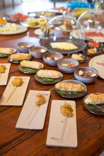 a wooden table with plates of food on chopsticks at Can Simoneta - Adults Only in Canyamel
