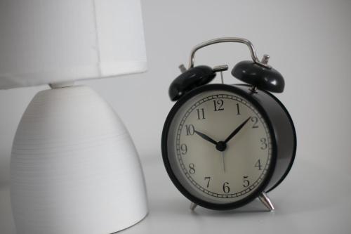 a black alarm clock sitting next to a lamp at House Smolčić in Otočac