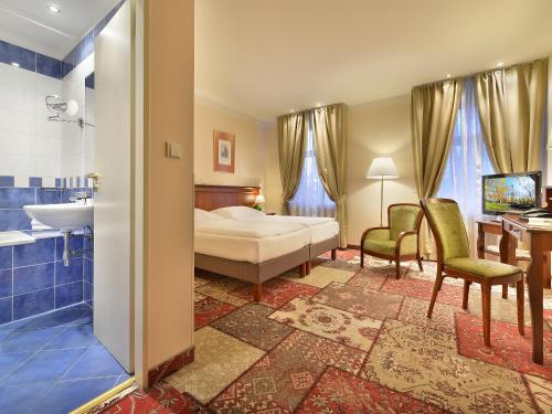 Postel nebo postele na pokoji v ubytování EA Hotel Jeleni Dvur Prague Castle
