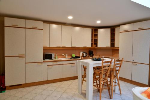 a kitchen with white cabinets and a table and chairs at Annis Wohnschlösschen in Mainhausen