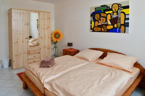 麥豪森的住宿－Annis Wohnschlösschen，卧室配有一张床,墙上挂有绘画作品