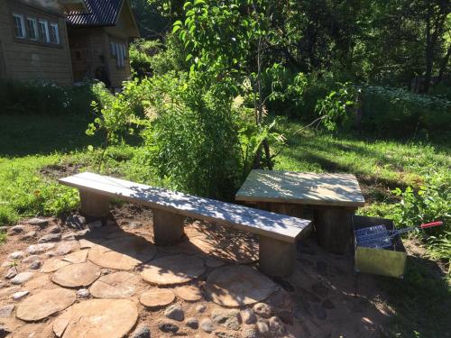 a wooden bench sitting on top of a stone ground at Ligatne's Village Studio Apartment in Līgatne