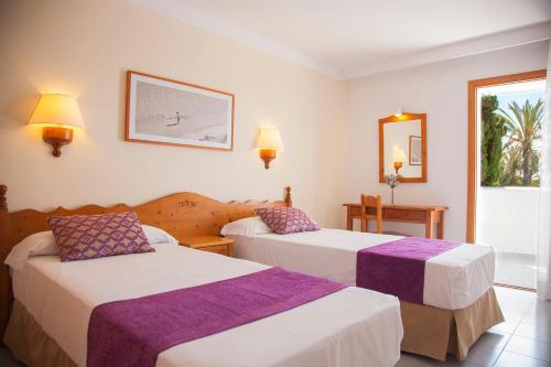 pokój hotelowy z dwoma łóżkami i lustrem w obiekcie Inturotel Azul Garden w mieście Cala d´Or