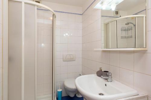 bagno bianco con lavandino e servizi igienici di Appartamento Via Roma a Stresa