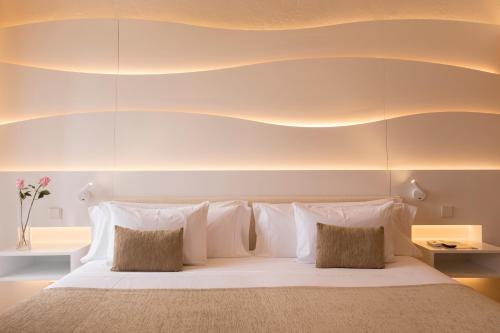 a bedroom with a large bed with white pillows at Can Simoneta - Adults Only in Canyamel