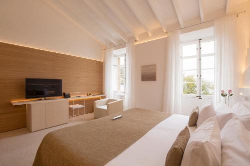 a bedroom with a large bed and a television at Can Simoneta - Adults Only in Canyamel