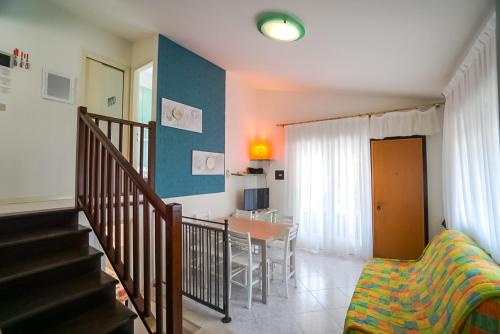 a living room with a staircase and a dining room at Villa Polluce in Bibione