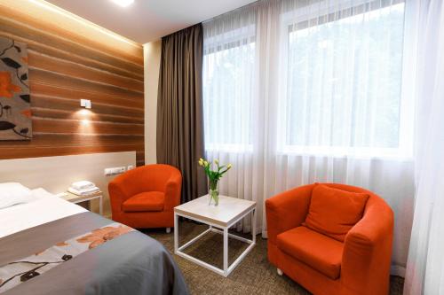 a hotel room with two chairs and a bed at Voevodyno Resort in Tur'ya Pasika