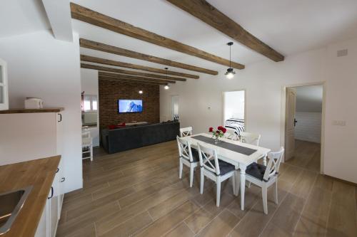 a kitchen and dining room with a white table and chairs at House Smolčić in Otočac