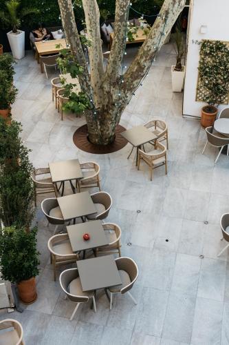 a patio with tables and chairs and a tree at Hôtel Boutique Cézanne centre Aix-en-Provence in Aix-en-Provence