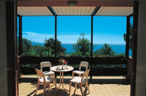 eine Terrasse mit einem Tisch und Stühlen sowie Meerblick in der Unterkunft Residence Pianeta Maratea in Maratea