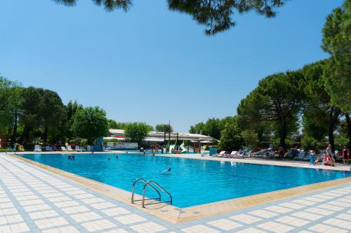 a large swimming pool with people swimming in it at New Campsite in Camping Ca' Savio in Cavallino-Treporti