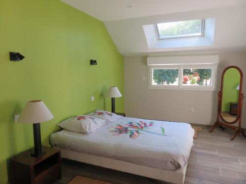 a bedroom with a bed and a window and a mirror at Le gîte de Ballage in Chemillé-sur-Dême