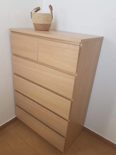 a wooden dresser with a basket on top of it at Orléans Appartement 2 chambres avec Parking in Orléans