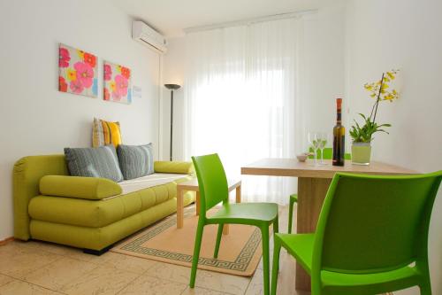 a living room with a yellow couch and green chairs at Villa Lavanda in Pag