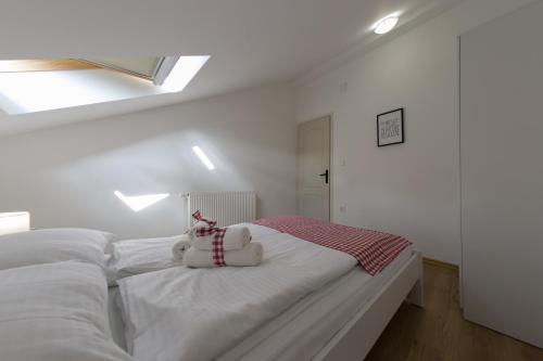 a white bed with a stuffed teddy bear on it at House Smolčić in Otočac