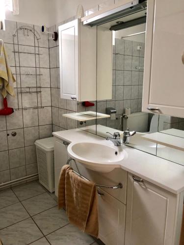 a white bathroom with a sink and a mirror at VODICE KRAJE APARTMENTS in Vodice