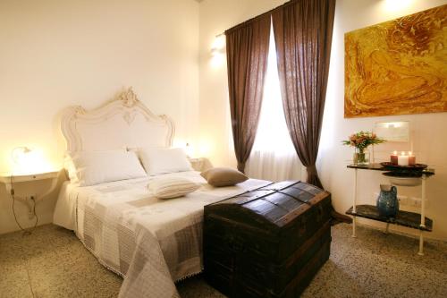 a bedroom with a bed with a white bedspread and a window at La Piccola Atene in Pietrasanta