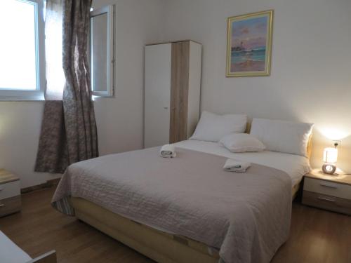a bedroom with a bed with two towels on it at Apartments Milica in Rogoznica