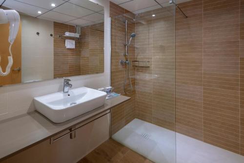 a bathroom with a sink and a glass shower at 4R Meridià Mar in Hospitalet de l'Infant