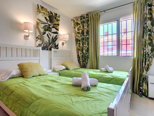 deux lits dans une chambre avec des draps verts dans l'établissement Arona 1 - 3908, à Mar de Cristal