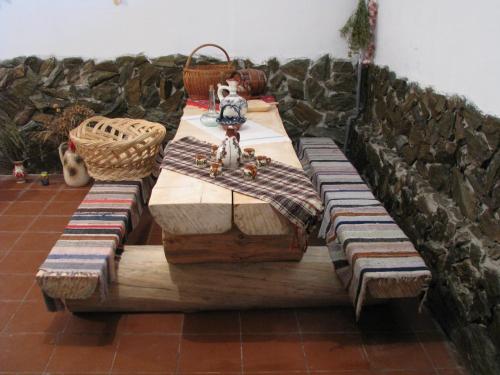 una mesa de madera con bancos y una máquina de coser en ella en Casa Renti, en Novaci-Străini