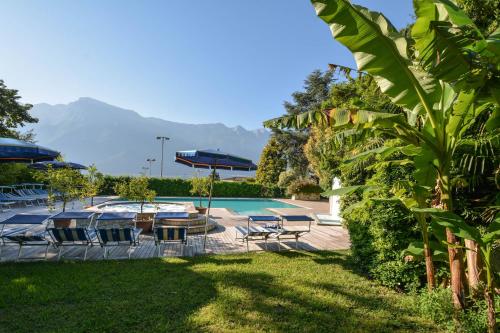 a resort with a pool and mountains in the background at Hotel Limone in Limone sul Garda