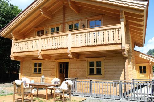 a log cabin with a table and chairs at Schlosswirt Chalets & Apartments in Großkirchheim