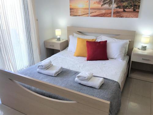 1 dormitorio con 1 cama con toallas en Kyklades Resort & Spa, en Paralimni