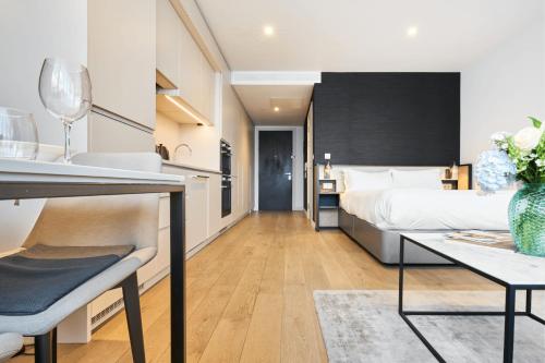 a bedroom with a bed and a table and a kitchen at CitySuites Aparthotel in Manchester