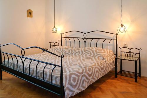 a bedroom with a bed with a metal frame and two lights at Sara in Bibinje