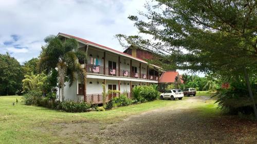 a building with cars parked in front of it at RTMS Guesthouse Semporna in Semporna